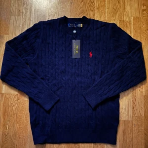 Mörkblå stickad tröja från Ralph Lauren - Säljer en stickad mörkblå Ralph lauren tröja. Skick är nyskick bara testad 1 gång😄. Finns inga defekter på tröjan och priset ej hugget i sten🪨