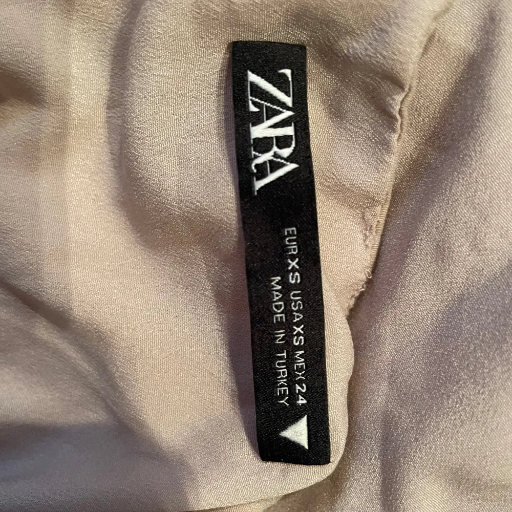 Säljer en snygg beige klänning/topö från Zara. Vikt upp till en topp, men är en klänningz Perfekt för varma dagar eller en utekväll🌟. Yläosat.