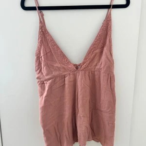 Rosa linne med spetsdetaljer - Gulligt rosa linne från pull and bear. Ganska gammalt finns inte att köpa längre och har några lösa trådar. 💖