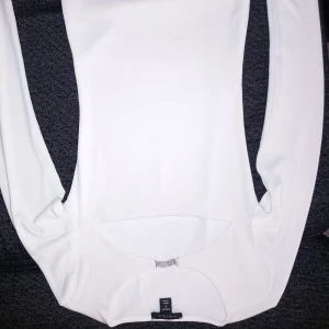 Vit långärmad topp från New Yorker - Säljer en stilren vit långärmad topp från Zara. Perfekt för en minimalistisk look. Toppen har en enkel design med rund halsringning och är tillverkad i ett mjukt material.