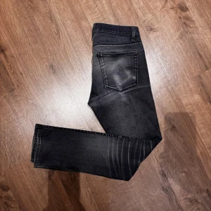 Acne Studios Jeans - Snygga gråa jeans från Acne Studios i en slim fit model. De har en riktigt schysst tvätt med unika ränder och slitningar, perfekt för en stilren och modern look.