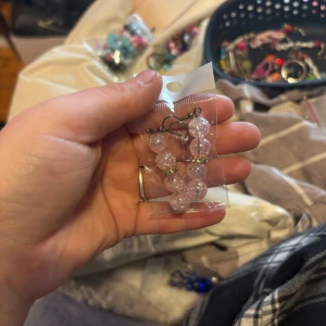 Rosa glittriga örhängen - Säljer ett par rosa glittriga örhängen med pärlor. De har en fin glans och är perfekta för att ge en extra touch till din outfit. Köp dem nu och lys upp din dag! 💖