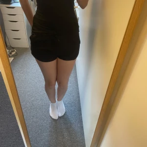 Svarta shorts med dragsko - Säljer ett par svarta shorts med elastisk midja och dragsko. Perfekta för en avslappnad stil. De har en bekväm passform och är gjorda i ett mjukt material.