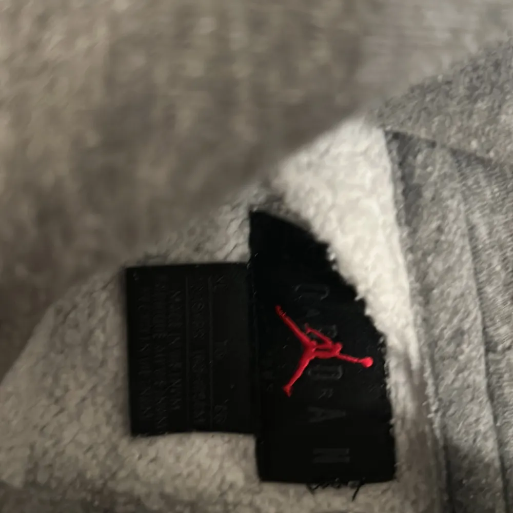 Säljer en grå hoodie från Jordan med en klassisk logga på bröstet och en signaturdetalj på ärmen. Tröjan har en stor ficka framtill och en bekväm huva. Perfekt för en avslappnad stil.. Neuletakit & Villapaidat.