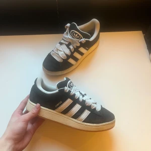 Svarta Adidas Campus sneakers - Snygga svarta Adidas Campus sneakers med vita detaljer och klassiska tre ränder på sidan. Storlek 39,5. I 10/10 skick