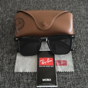Ray-Ban liknande solglasögon - Snygga svarta solglasögon liknade Ray-Ban med klassisk design. De har en fyrkantig form. Perfekta för en stilren look. Fodralet igår inte. Undran om frågor är det bara fråga.