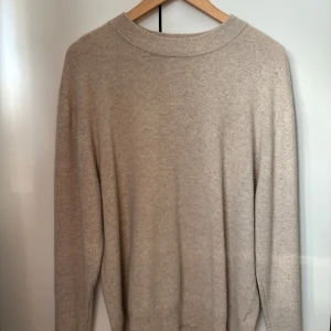 Beige kashmirtröja från Soft Goat - Säljer en helt oanvänd kashmirtröja från Soft Goat, säljer då den aldrig kommer till användning. Tröjan har en ribbad krage och passar perfekt nu till våren. Nypris: 2895kr