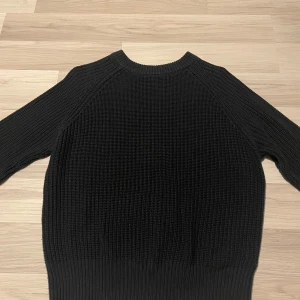 Svart stickad tröja - Säljer en stilren svart stickad tröja med rund hals och långa ärmar. Perfekt för kyligare dagar och enkel att matcha med olika outfits.