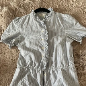 Randig blus från Kimchi & Blue - Säljer en söt randig blus från Kimchi & Blue i storlek XS med ett skärp till. Perfekt för en sommaren