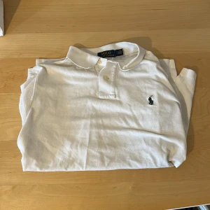 Ralph Lauren piké - Tja! Säljer en klassisk vit pikétröja från Ralph Lauren i slim fit. Storlek L men jag skulle säga att den sitter mer som en M dä den sitter väldigt tight runt armarna💪Overall en skitsnygg tröja i perfekt skick!