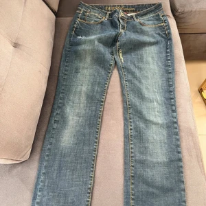 Blå jeans från Guess - Säljer ett par klassiska blå jeans från Guess. De har en straight passform med snygga slitningar och kontrastsömmar. Perfekta för en avslappnad stil. Storlek 32. 40cm tvärsöver. Pris går att diskuteras!🩷