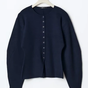 Ginatricot - Knitted Sculptured Cardigan - Säljer en stilren mörkblå kofta från Ginatricot med knappar framtill. Perfekt för en avslappnad look. Koftan har långa ärmar och en rund halsringning. Prislapp finns kvar på plagg och har inte använt tröjan mer än en gång!💙☺️