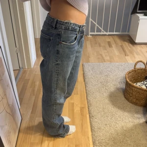 Blå jeans från Zara - Säljer ett par klassiska blå jeans med rak passform. De har en hög midja och femficksdesign. Perfekta för en avslappnad stil.