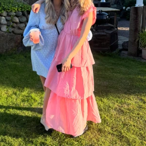 Rosa långklänning med volanger - Superfin rosa sommarklänning, endast använd en gång💕💗den har lite öppen rygg med knytdetalj i nacken, skriv för fler bilder!