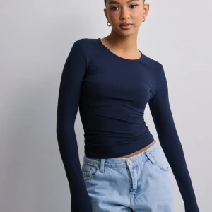 Mörkblå långärmad topp - Snygg och enkel mörkblå långärmad topp med rund halsringning. Använd fåtal gånger och är i mycket bra skick.