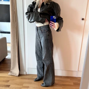 Gråa baggy, raka jeans - Säljer ett par gråa jeansbyxor med rak passform och hög midja. Storlek 34. Jag är 158cm lång men har ca 7cm klackar på mig på bilderna. Jeansen är använda men tycker de blir snyggare ju mer slitna de är ;) de är coola!