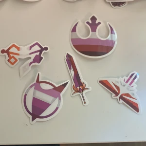 Stickerpaket med pride-tema - Ett färgglatt stickerpaket med motiv inspirerade av fantasy, sci-fi och symboler i pridefärger. Perfekt för att dekorera dator, mobil eller anteckningsbok och visa din personlighet och stolthet.