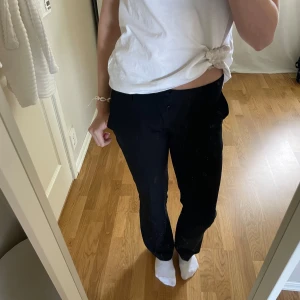 Svarta kostymbyxor från BikBok - Säljer ett par populära svarta kostymbyxor som är slutsålda från BikBok med klassisk passform och utsvängda ben. Byxorna har dragkedja och knapp framtill och är i storlek 34. 