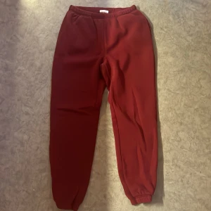 Vinröda mjukisbyxor från Ginatricot - Mysiga vinröda mjukisbyxor från Ginatricot med resår i midjan och vid bensluten. Perfekta för chill eller träning, i mjukt material som känns skönt mot huden.