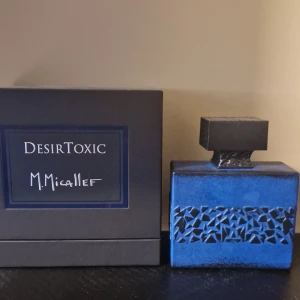 DesirToxic parfym från M. Micallef nypris 2700 ungefär 93 ml kvar - Exklusiv parfym DesirToxic från M. Micallef i en lyxig blå flaska med svart dekor och matchande svart lock. Kommer i en elegant svart kartong med tydlig logga. Perfekt för dig som gillar unika dofter och snygg design.