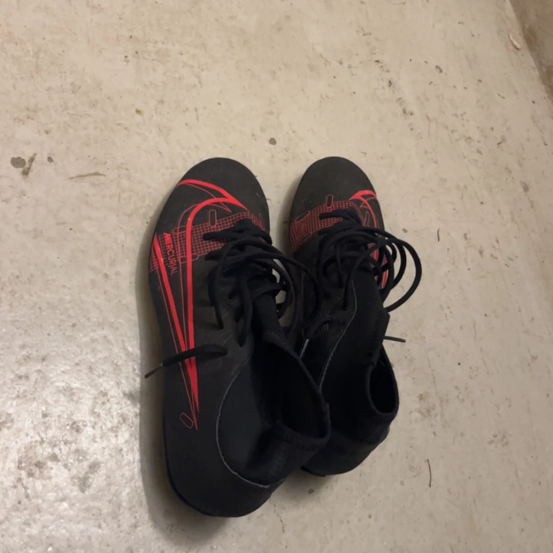 Svarta fotbollsskor från Nike med röda detaljer