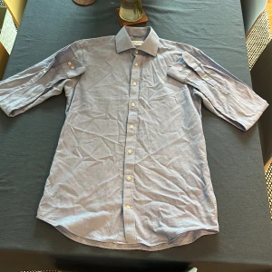 Ljusblå skjorta från John Henric - Säljer en klassisk ljusblå skjorta från John Henric i storlek 39, men den sitter som M. Skjortan har lång ärm, vit knappstängning och klassisk krage. Perfekt för dig som gillar stilrena och tidlösa plagg.