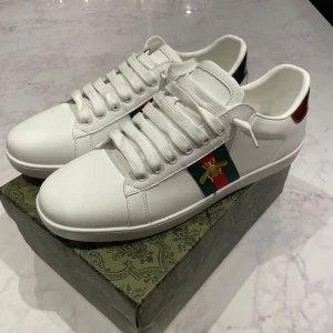 Gucci vita sneakers med broderad bi - Säljer ett par sjukt snygga Gucci ace skor till sommaren som är i nyskick vilket man ser på bilderna. Har du andra frågor eller funderingar tveka inte på att höra av dig. Mvh Noah