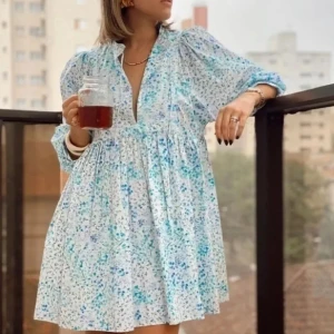 Blommig ljusblå kortklänning med v-ringning - Superfin ljusblå kortklänning med blommigt mönster och v-ringning. Klänningen har trekvartsärmar med lätt puff och avslappnad passform. Perfekt för varma dagar och har en luftig känsla. Storlek XS (S)