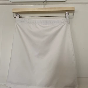 Vit kortkjol i stretchigt material - Garderobsrensning pågår! 👗 Shoppa loss bland en massa fina plagg. Kika in på min sida, så kanske du hittar något mer du gillar!  Har du frågor om ett plagg? Tveka inte att höra av dig!  (OBS: Kan tyvärr inte ta bilder med plaggen på.)