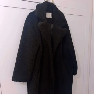 Svart teddyjacka  - Mysig svart teddyjacka med stor krage och lång ärm. 