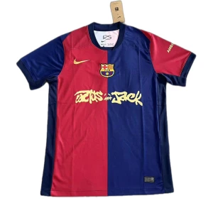 FC Barcelona x Travis Scott Home Jersey (fan edition) - Säljer en officiell FC Barcelona x Cactus Jack matchtröja i rött och blått med klubbmärke och Nike-logga på bröstet. Tröjan har gul text på magen och UNHCR-logga på ryggen. Klassisk rak passform och korta ärmar.