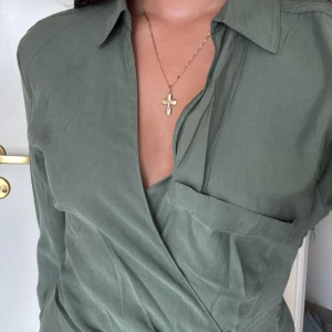 Olivgrön omlottklänning från Zara - Säljer en grön skjort liknande klänning som är tight i midjan med prislapp på. Nypris 399💕