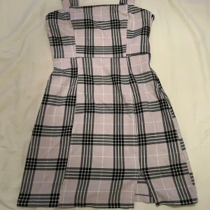 Rutig kort klänning från H&M  - Superfin kort klänning med breda axelband från H&M. Dragkedja i sidan och ett litet slitt framtill. Storlek 34