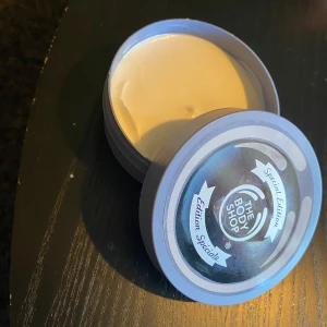 The Body Shop Blueberry Body Butter - Limited edition Blueberry Body Butter från The Body Shop i en lila rund burk, 200 ml. Rik och krämig formula med blåbärsdoft som smälter in i huden och ger massor av fukt. Perfekt för dig som älskar fruktiga dofter och mjuk hud.