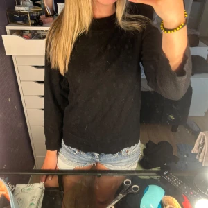 Svart basic stickad tröja - Enkel svart stickad tröja. Modellen är rak och har en klassisk passform som funkar till det mesta. Perfekt att slänga på sig när det är lite kyligare ute.