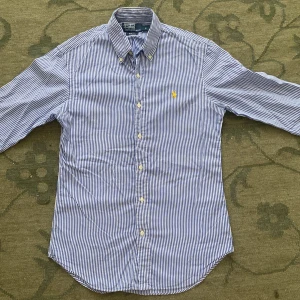 Randig skjorta från Polo Ralph Lauren - Snygg blå- och vitrandig skjorta från Polo Ralph Lauren i slim fit-modell. Nypris: 1500kr