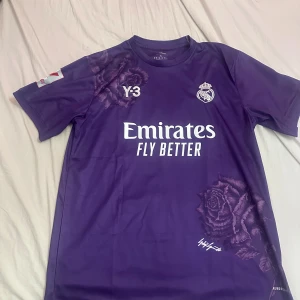 Lila Real Madrid Bellingham fotbollströja - Säljer en lila Real Madrid fotbollströja med Bellingham och nummer 5 på ryggen i storlek XL. 