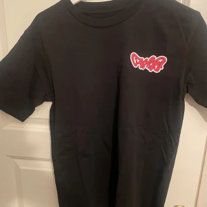 Svart Off-White t-shirt med tryck - Svart t-shirt från Off-White med färgglada grafiska tryck och loggor på både bröstet och ryggen. Klassisk passform med rund hals och korta ärmar. Materialet känns som bomull och trycken ger en riktigt streetig vibe.