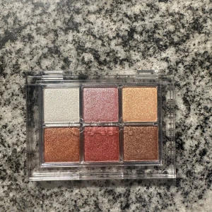 Caiacosmetics Disco Fever ögonskuggspalett - Disco Fever ögonskuggspalett från Caiacosmetics med sex skimrande nyanser i guld, koppar, rosa, brons och champagne. Perfekt för att skapa glittriga och färgstarka ögonlooks. Aldrig använd. Nypris 365kr säljer för 275kr.