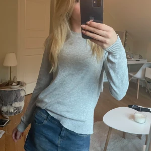 Ljusgrå stickad tröja från H&M - En enkel och stilren ljusgrå stickad tröja från H&M Basics. Tröjan har rund halsringning, ribbade muddar och är långärmad. Säljer då jag har för många tjocktröjor. Inga defekter och i mycket bra skick!❤️