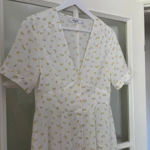 Söt sommarklänning - Jättefin sommarklänning med gula blommor. Den är medellång och tyget är något transparent. 