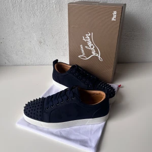 Mörkblåa Christian Louboutin skor med spikar - Säljer ett par helt oanvända Christian Louboutin skor i mörkblåfärg med spikar. Skorna är i storlek 42 och i extremt bra skick eftersom de är helt oanvända. Originalpriset på dessa ligger på 10500kr