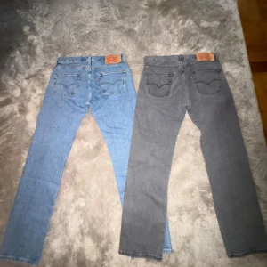 Helt nya Levi's 501 jeans blå & grå - Två par helt nya klassiska Levis 501 Jeans, ett par i ljus blått denim och ettt par i grått. Dem är väldigt sköna och perfekta för en tidslös stil. Båda av byxorna är använda max 2 gånger och har inge skador alls. Jag säljer dem för att de inte passar min nuvarande stil och jag inte anvönde dem så som jag trodde jag skulle. Skriv vid frågor eller vid behov av mer bilder.Om man bara vill köpa ett par så är det 300kr per par. !!OBS!! Pris kan diskuteras vid snabb affär. 