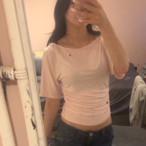 Rosa T-shirt med detaljer  - Rosa T-shirt med detaljer, tajt runt magen, lösare upptill armarna. Från lager 157. Endast testad, får ej användning av den därför säljer jag. Köpte för 150kr. Pris kan diskuteras och skriv vid funderingar/frågor eller för fler bilder💓🥰