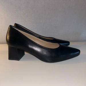 Svarta Klackskor Stockholm Design Group storlek 39 - Jättefina klackskor inköpta i år. Ganska låg klack. Använda några gånger. För stora i storleken på mig. Bra skick förutom några repor och nött på insidan vid hälarna.