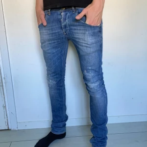 Dondup George jeans med slitningar  - Säljer ett par feta jeans från Dondup i modellen George (slim fit) med slitningar. Skick 7/10, storlek 30/30. Slitningen på vänster knä går igenom och lappen innanför midjan är ganska sliten men det inget som synns eller känns när man bär dem. Vid frågor osv är det bara att höra av sig! 🙂(pris absolut inte hugget så kom med prisförslag om ni vill)