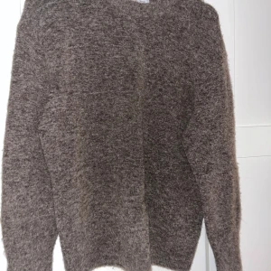 Brun stickad tröja & Other Stories XS - Mysig brun stickad tröja från & Other Stories Stockholm Atelier i storlek XS. Tröjan har en klassisk rak passform och långa ärmar, perfekt för lager på lager under kyliga dagar. Materialet är mjukt och fluffigt, vilket gör den extra skön att bära.