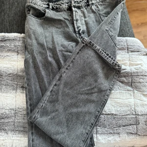 Grå jeansbyxor från only & sons  - Snygga grå jeansbyxor från only & sons  i loose fit-modell. Byxorna har klassisk femficksdesign, normal midja och raka ben. Perfekta för en avslappnad stil och passar till det mesta. Materialet är slitstarkt och bekvämt.
