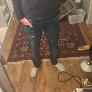 Mörkblå jeans från Jack & Jones - Stilrena jeans med slitningar ifrån Jack and Jones. Storlek 33 och 34. Liten difekt på lappen på baksidan men inget man märker av. Kom gärna med prisförslag. Priset står inte fast i sten!!!