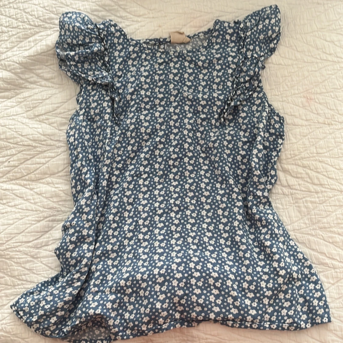 Blommig blå blus med volangdetaljer